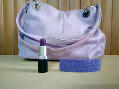 mini bolso, pinta labios y pasador para pelo